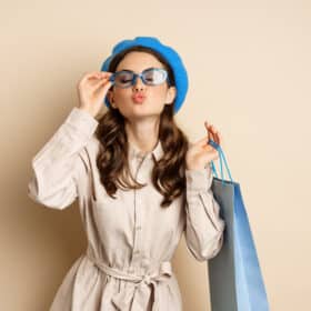 Happy young woman shopping while holding a shopping bag